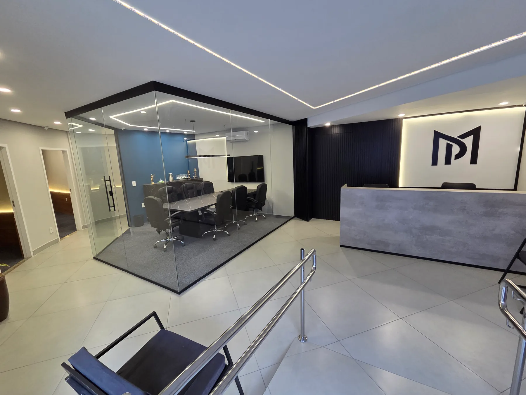 Recepção do escritório Miranda & Porto com a marca na parede e sala de reunião